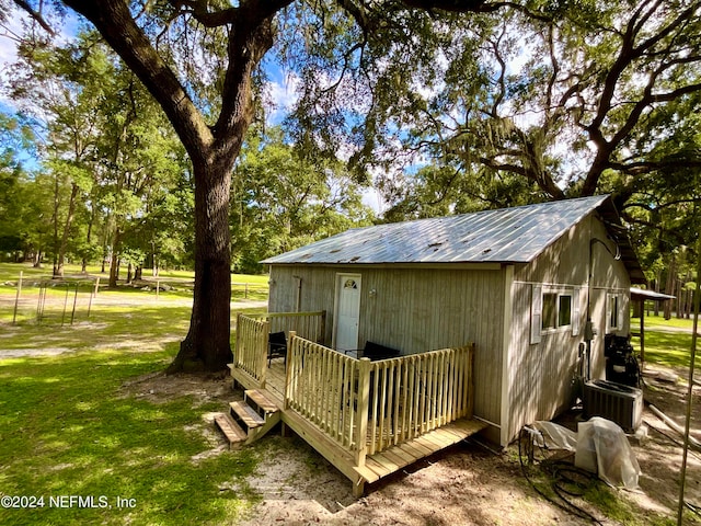 view of outbuilding featuring a yard and central AC