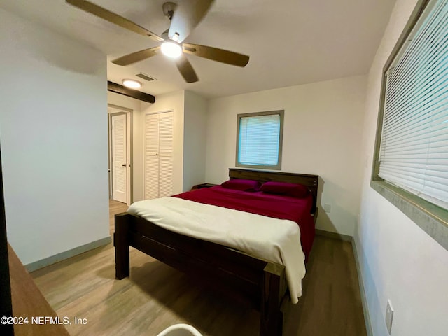 bedroom with multiple windows, ceiling fan, and wood-type flooring