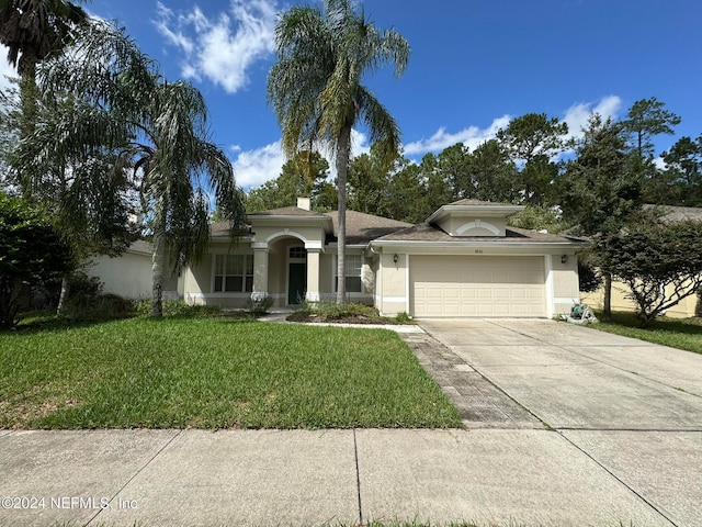 view of front of house with a front yard and a garage