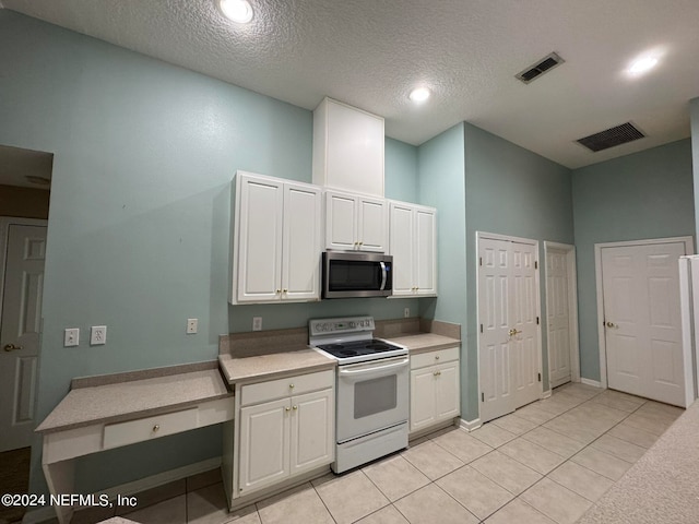 kitchen featuring electric stove, white cabinets, a textured ceiling, and light tile patterned floors