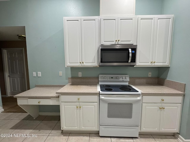 kitchen with white cabinets, white electric range oven, and light tile patterned flooring