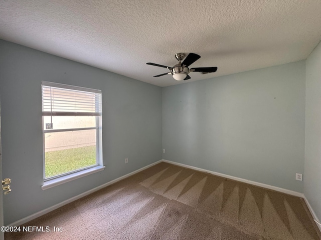 carpeted empty room featuring ceiling fan and a textured ceiling