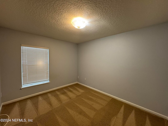 carpeted empty room with a textured ceiling