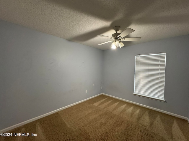 carpeted spare room with ceiling fan and a textured ceiling