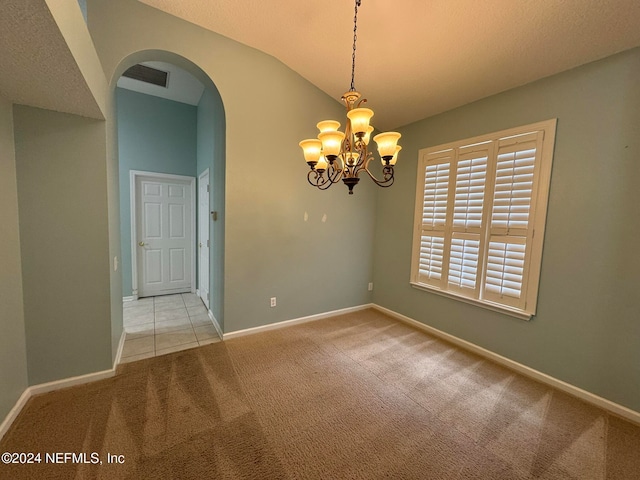 empty room featuring lofted ceiling, a chandelier, and light colored carpet