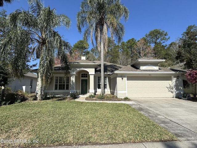 view of front of house featuring a garage, a front yard, concrete driveway, and stucco siding