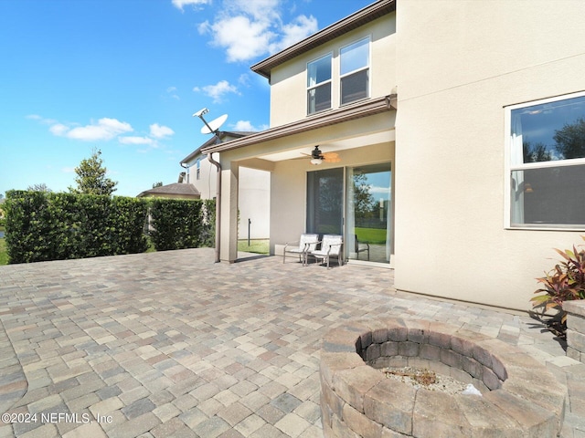 view of patio / terrace with ceiling fan and a fire pit