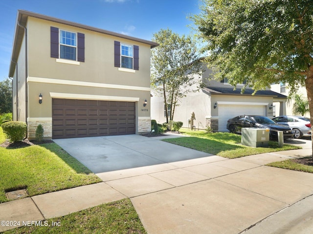 view of property with a front lawn and a garage