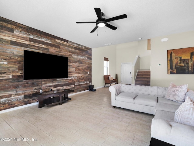 living room with ceiling fan and wooden walls