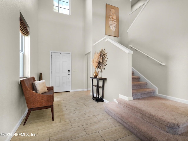 foyer entrance featuring a high ceiling and light hardwood / wood-style floors