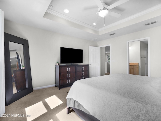 bedroom featuring light carpet, ceiling fan, a tray ceiling, crown molding, and ensuite bath