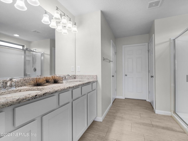 bathroom featuring vanity, a textured ceiling, and walk in shower