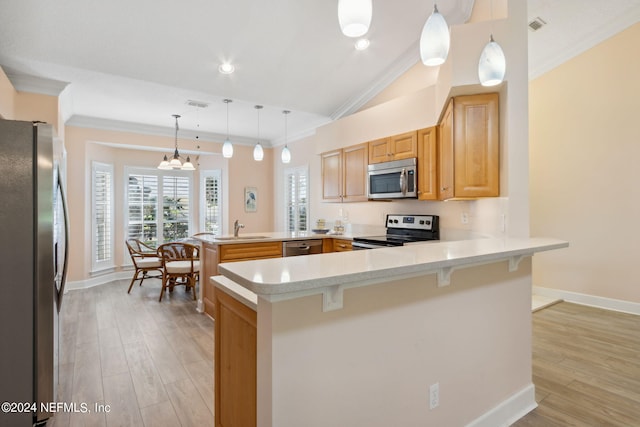 kitchen featuring a kitchen breakfast bar, kitchen peninsula, stainless steel appliances, and hanging light fixtures