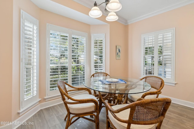 dining room featuring an inviting chandelier, light hardwood / wood-style flooring, plenty of natural light, and crown molding