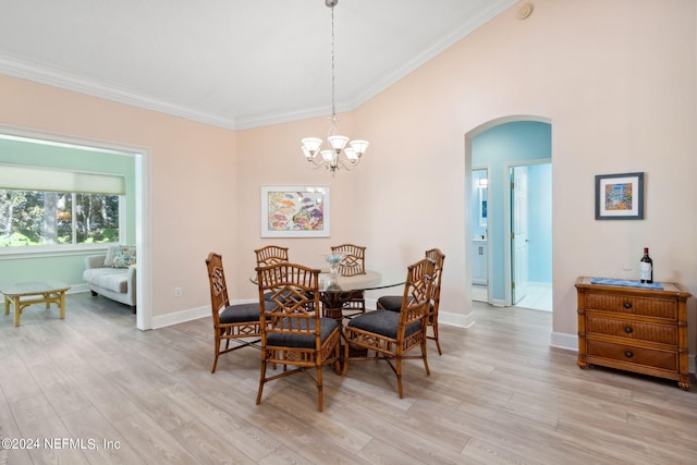 dining space with crown molding, an inviting chandelier, and light wood-type flooring