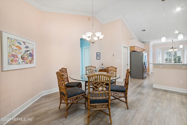 dining space with light hardwood / wood-style flooring, ornamental molding, a notable chandelier, and vaulted ceiling