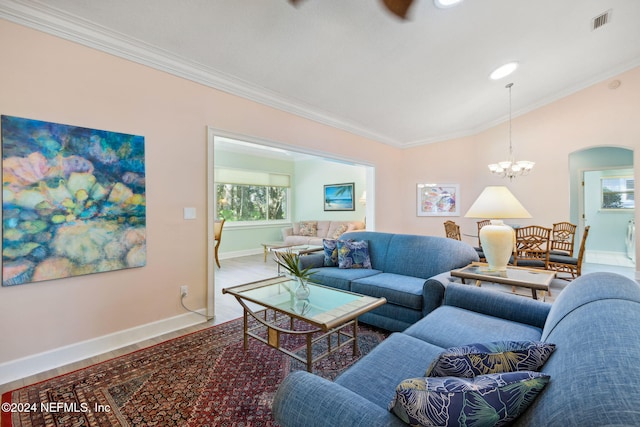 living room with an inviting chandelier, crown molding, and hardwood / wood-style flooring