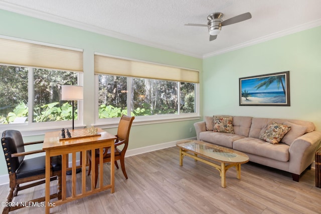 living room with light hardwood / wood-style floors, ornamental molding, a textured ceiling, and ceiling fan