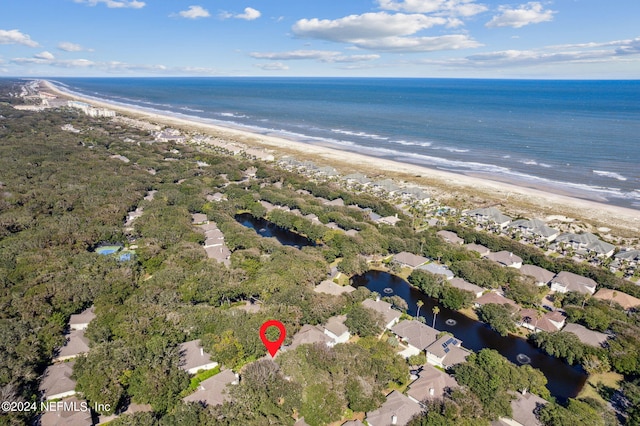 birds eye view of property with a water view and a beach view