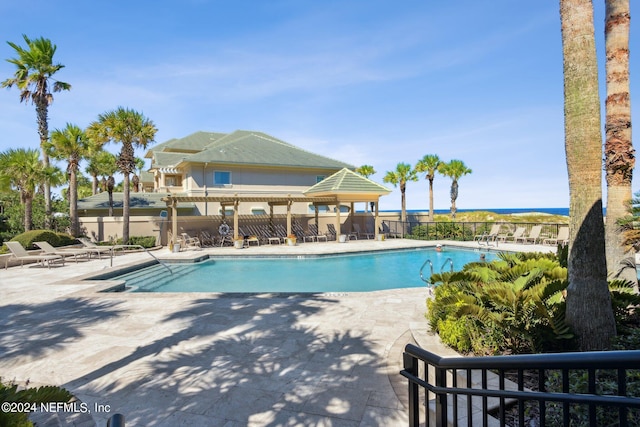 view of pool featuring a patio, a gazebo, a water view, and a pergola