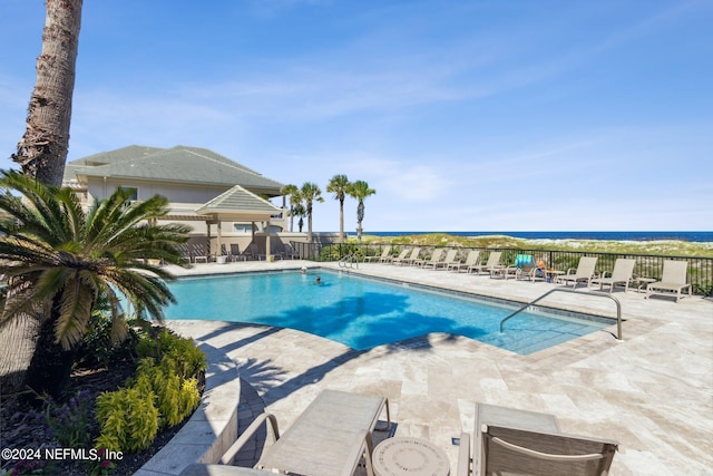 view of swimming pool with a water view and a patio