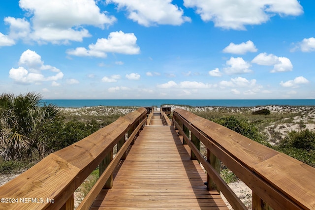 view of property's community featuring a water view and a beach view