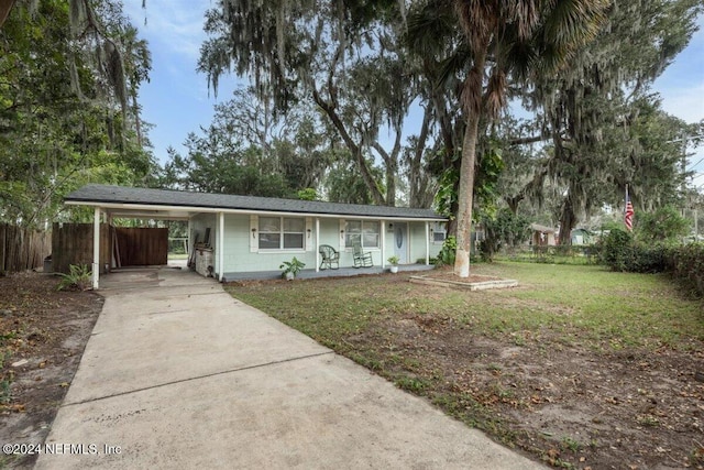 single story home featuring a porch, a front lawn, and a carport