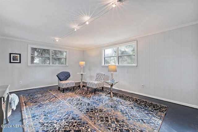 sitting room with crown molding and concrete floors