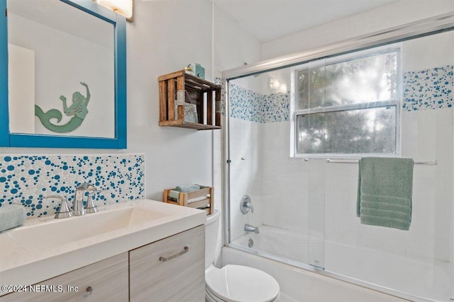 full bathroom featuring tile walls, vanity, shower / bath combination with glass door, and toilet