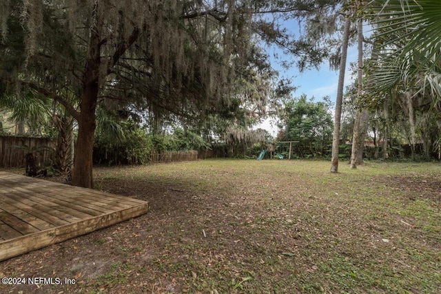 view of yard featuring a playground and a wooden deck