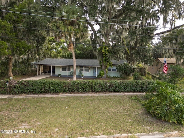 view of front of home with a front yard and a carport