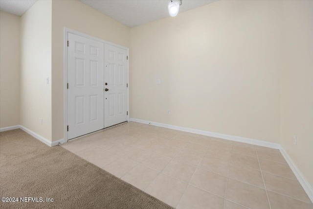 empty room featuring light colored carpet and a textured ceiling