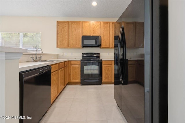 kitchen featuring light tile patterned flooring, sink, a textured ceiling, black appliances, and decorative backsplash