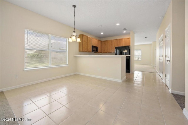 kitchen with pendant lighting, light tile patterned floors, a textured ceiling, a chandelier, and black appliances