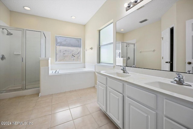 bathroom with tile patterned floors, vanity, independent shower and bath, and a textured ceiling