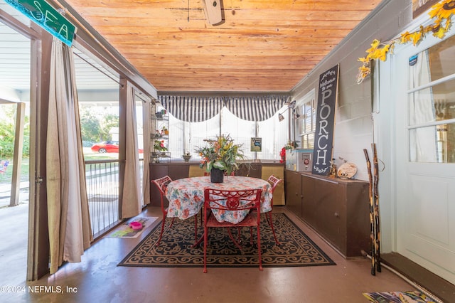 dining room featuring wood ceiling and concrete floors