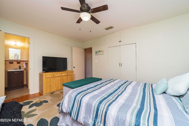 bedroom with connected bathroom, ceiling fan, a closet, and light hardwood / wood-style flooring