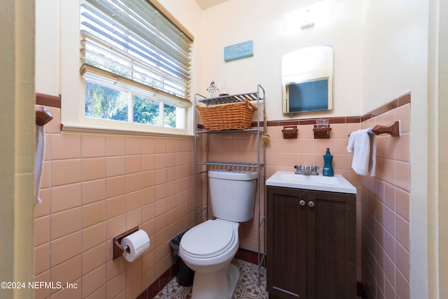 bathroom featuring tile patterned flooring, vanity, tile walls, and toilet