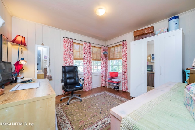 bedroom featuring ensuite bath and dark wood-type flooring