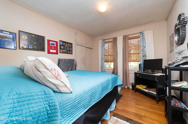 bedroom featuring wood-type flooring and ornamental molding