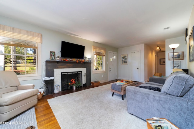 living room featuring light hardwood / wood-style floors and a brick fireplace