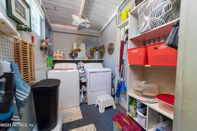 clothes washing area featuring washing machine and dryer, dark carpet, and wooden ceiling