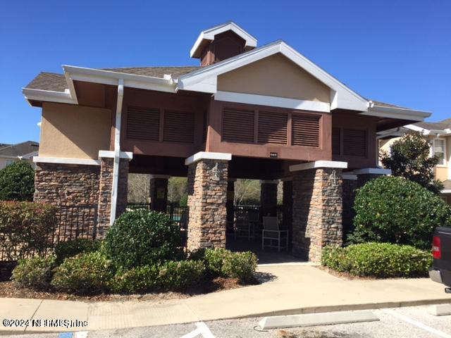view of front of house featuring stucco siding and stone siding
