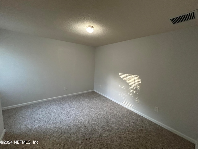 spare room with carpet floors and a textured ceiling