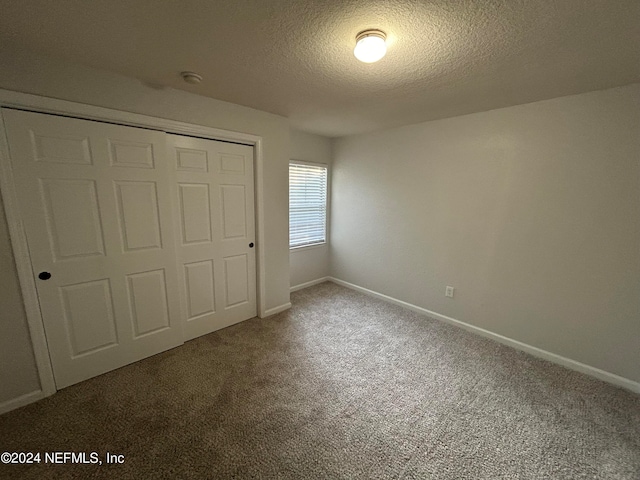 unfurnished bedroom featuring carpet floors, a closet, and a textured ceiling