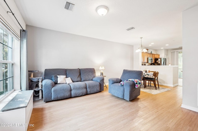 living room featuring light hardwood / wood-style floors and a notable chandelier