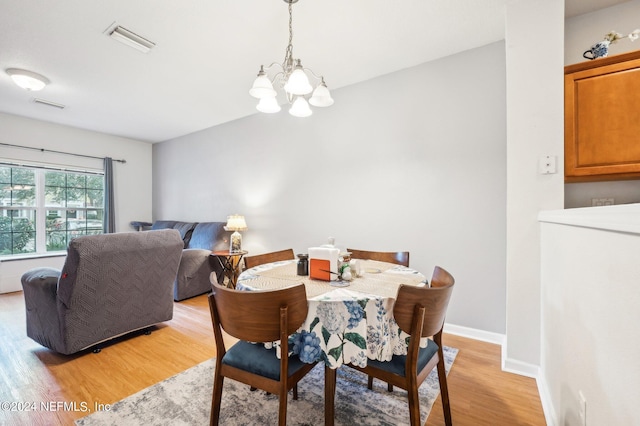 dining room with a chandelier and light wood-type flooring