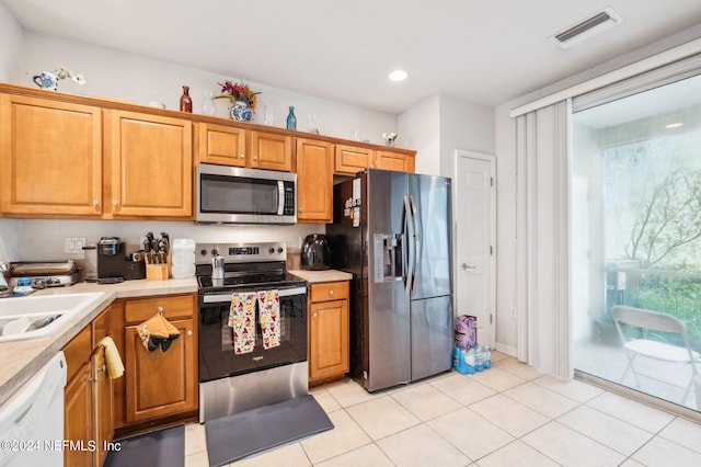 kitchen featuring sink, appliances with stainless steel finishes, and light tile patterned flooring