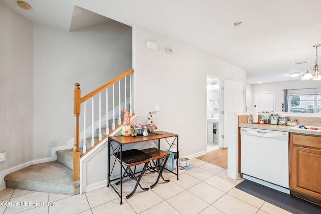 kitchen with dishwasher, a chandelier, and light tile patterned floors