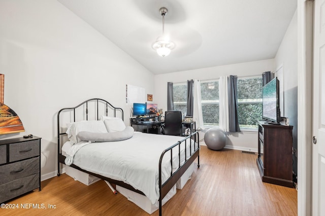 bedroom featuring vaulted ceiling and light wood-type flooring